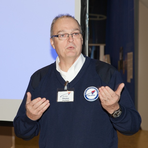 Conférencier présentant une mission spatiale devant un public attentif